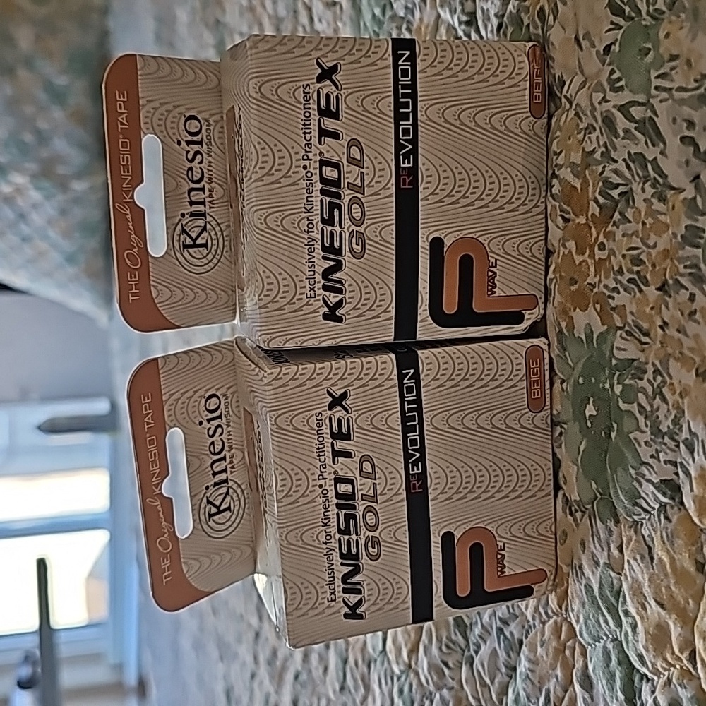 Two brand new unopened boxes of Kinesio Tex Gold tape in beige.